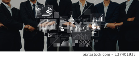 Business team in formal suits with digital interface displaying graphs, charts, and data analytics, representing collaboration in a corporate environment Trope Business team in formal suits with digital interface displaying graphs, charts, and data analytics, representing collaboration in a corporate environment Trope 137401935