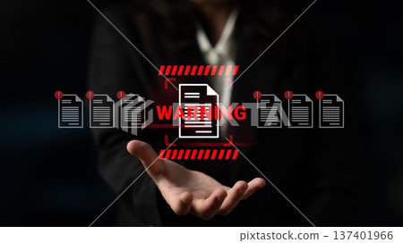 Business professional presenting a warning message with caution symbols and document icons in a dark environment for corporate urgency and compliance concepts Gantry Business professional presenting a warning message with caution symbols and document icons in a dark environment for corporate urgency and compliance concepts Gantry 137401966