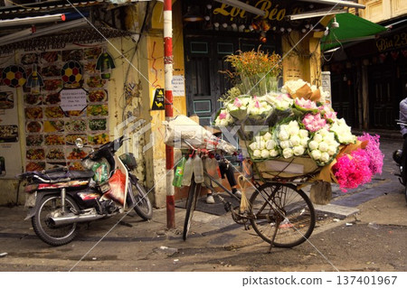 一輛自行車停在河內老城區(越南)的街角,車上的人正在賣蓮花。 一輛自行車停在河內老城區(越南)的街角,車上的人正在賣蓮花。 137401967