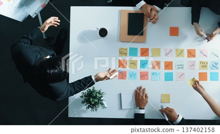 Business people looking at marketing idea written on sticky notes. Directorate. 137402158