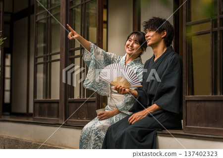 Ryokan, old house, Japanese house veranda, couple in yukata looking at the view, sky Ryokan, old house, Japanese house veranda, couple in yukata looking at the view, sky 137402323