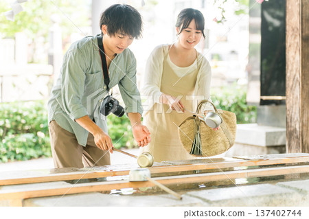 Men and women purifying themselves at the shrine's chozuya 137402744