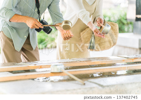 Men and women purifying their hands at the chozuya (purification fountain) of a shrine 137402745