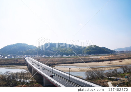 Yawata City, Kyoto - View of Hatoga Mine (Otokoyama), Kizugawa Miyuki Bridge and the Kizugawa River from the observation tower (southward, early spring) 137402870