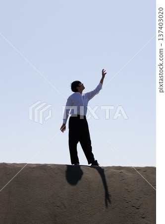Silhouette of a man looking up at the sky Silhouette of a man looking up at the sky 137403020