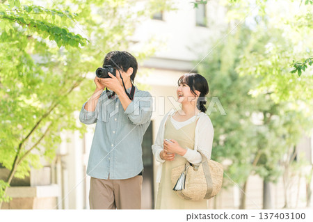 Man and woman taking photos with a single-lens reflex camera on a trip 137403100