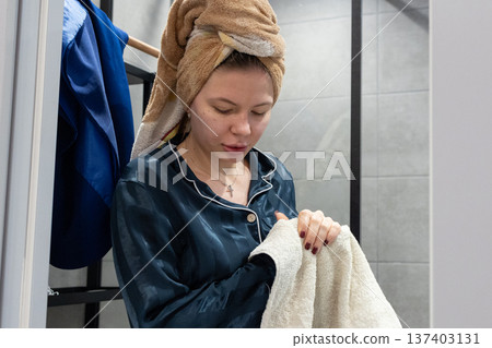 Woman drying hands with towel in bathroom Woman drying hands with towel in bathroom 137403131