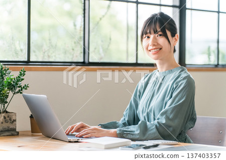 Young Asian woman teleworking/nomad working in a cafe Young Asian woman teleworking/nomad working in a cafe 137403357