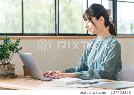 Young Asian woman teleworking/nomad working in a cafe Young Asian woman teleworking/nomad working in a cafe 137403358