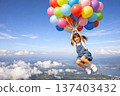 女孩帶著氣球在空中飛翔 137403432