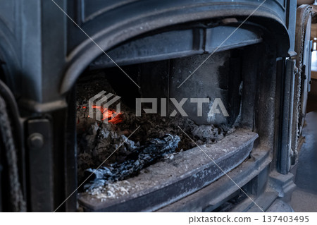 Red-hot charcoal embers in a wood-burning stove, a winter heating appliance Red-hot charcoal embers in a wood-burning stove, a winter heating appliance 137403495