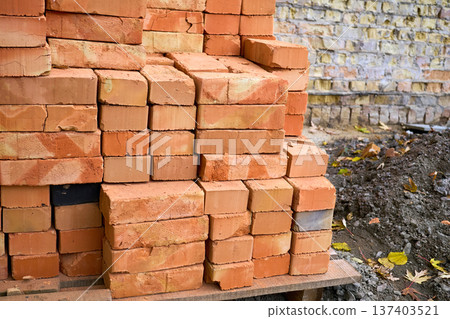 Stacked bricks on a wooden pallet on construction site 137403521