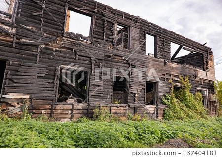 Charred wooden house exterior standing derelict after a devastating fire Charred wooden house exterior standing derelict after a devastating fire 137404181