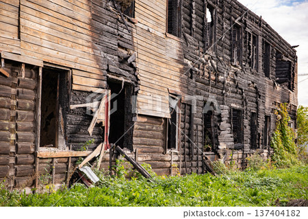 Abandoned log house aftermath showing extensive fire damage and destruction 137404182