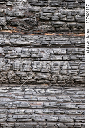 Charred wood texture creating a dark abstract background with carbonized surface Charred wood texture creating a dark abstract background with carbonized surface 137404187