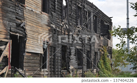 Burned house in destruction, charred wood and logs showing fire damage Burned house in destruction, charred wood and logs showing fire damage 137404226