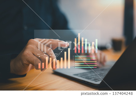 Businessman analyzing future growth forecast with digital bar graphs and charts on laptop Businessman analyzing future growth forecast with digital bar graphs and charts on laptop 137404248