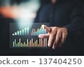 Businessman interacting with virtual colorful bar charts displaying data analysis and growth trends 137404250
