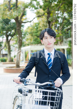 Businessman walking while pushing a bicycle 137404792