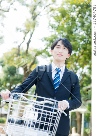 Businessman walking while pushing a bicycle Businessman walking while pushing a bicycle 137404793