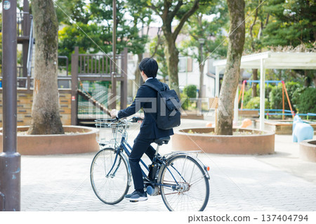 Businessman walking while pushing a bicycle Businessman walking while pushing a bicycle 137404794