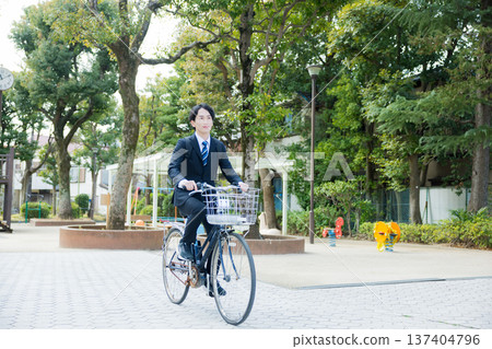 Businessman walking while pushing a bicycle Businessman walking while pushing a bicycle 137404796