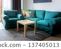 Cozy teal sofa with pillows and coffee table 137405013