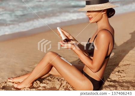 Sexy suntan bikini woman legs relaxing lying down on beach . Beauty skincare sun aging protection body care of tanned skin. Epilation laser or shaving concept. summer vacation.Skincare. 137406243