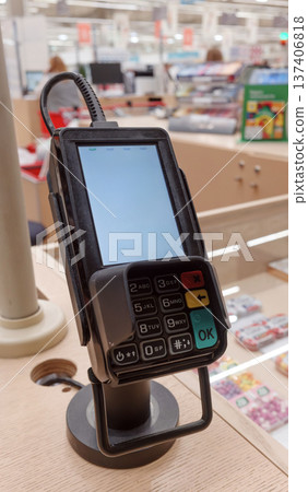 Payment terminal on checkout counter in retail store. Payment terminal on checkout counter in retail store. 137406818