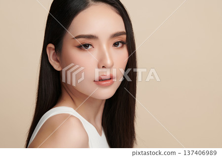 A beautiful young Asian woman with clean, fresh skin against a beige background. Skincare, facial treatment, cosmetology, beauty, and spa. An elegant portrait of an Asian woman. A beautiful young Asian woman with clean, fresh skin against a beige background. Skincare, facial treatment, cosmetology, beauty, and spa. An elegant portrait of an Asian woman. 137406989