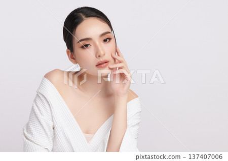 A beautiful young Asian woman with clean, fresh skin against a white background. Skincare, facial treatment, cosmetology, beauty, and spa. An elegant portrait of an Asian woman. 137407006