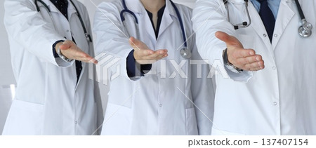 Medical team offering helping hands, extending invitation for support and showing professional care, welcoming patients to healthcare services with open palms Medical team offering helping hands, extending invitation for support and showing professional care, welcoming patients to healthcare services with open palms 137407154