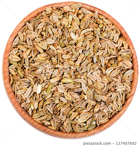 Fennel seeds in a small wooden bow isolated on white. Fennel seeds in a small wooden bow isolated on white. 137407692