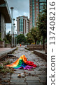A rainbow flag laying on the ground in the middle of a city street 137408216