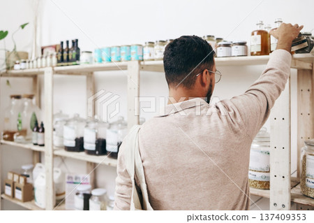 Customer, back and shopping by shelf in grocery store for healthy food, nutrition and wellness product sales. Choice, decision and nutritionist man in supermarket for retail purchase, buying or deal 137409353