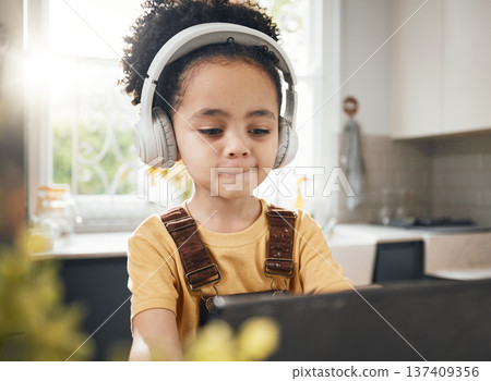 Tablet, headphones and kid in online education in home, elearning or homeschool in kitchen. Serious, technology and boy child on video call, study on internet and listening to music in virtual class 137409356