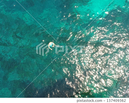 Above, swimming and a person in the ocean in summer for a beach vacation, travel or relax in the water. Nature, sunshine and a man in the sea for stress relief, holiday or happy with a drone view Above, swimming and a person in the ocean in summer for a beach vacation, travel or relax in the water. Nature, sunshine and a man in the sea for stress relief, holiday or happy with a drone view 137409362