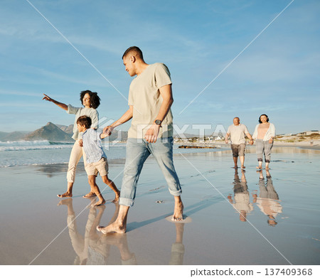 Big family, holding hands and walking at the beach with conversation, relax and bond on blue sky background. Love, child and parent with grandparent at the ocean for travel, fun and freedom in Bali Big family, holding hands and walking at the beach with conversation, relax and bond on blue sky background. Love, child and parent with grandparent at the ocean for travel, fun and freedom in Bali 137409368