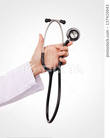 Stethoscope in hand, doctor and health, cardiology and wellness with equipment isolated on white background. Cardiovascular healthcare, listen to heart beat and person in studio with medical tools 137410043