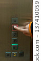 The child is pressing the button in the elevator. 137410059