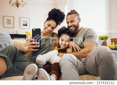 Interracial parents, child and selfie on sofa, smile and hug for love, bonding and memory on web blog. Mom, dad and kid for photography, profile picture and happy for social media app in family house 137410112
