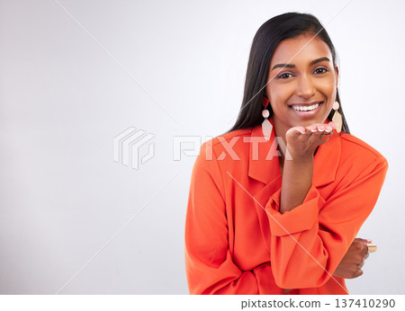 Smile, portrait and Indian woman blowing kiss in studio for flirting, care or romance gesture on grey background. Happy, face and female model with hand kissing emoji for thank you, gratitude or love Smile, portrait and Indian woman blowing kiss in studio for flirting, care or romance gesture on grey background. Happy, face and female model with hand kissing emoji for thank you, gratitude or love 137410290