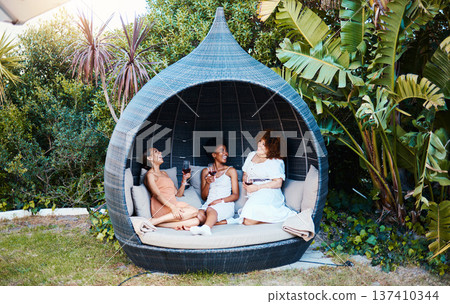 Travel, luxury and happy women on vacation talking in a conversation or friends on an outdoor getaway together. Wine, laughing and people on holiday in nature bonding in happiness in a modern tent Travel, luxury and happy women on vacation talking in a conversation or friends on an outdoor getaway together. Wine, laughing and people on holiday in nature bonding in happiness in a modern tent 137410344