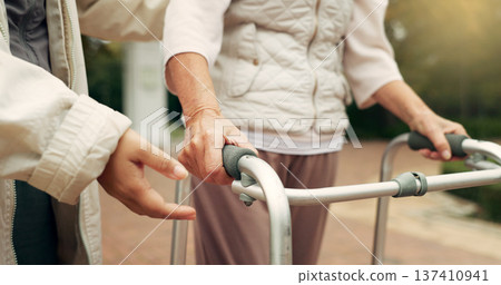Hands, support and senior person with a walker for injury rehabilitation, walking help and physiotherapy. Healthcare, patient with a disability and gear for nursing in retirement with a caregiver Hands, support and senior person with a walker for injury rehabilitation, walking help and physiotherapy. Healthcare, patient with a disability and gear for nursing in retirement with a caregiver 137410941