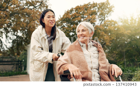 Elderly woman, wheelchair and nurse in park, nature or garden outdoor. Happy, senior person with a disability and walking with caregiver for health, wellness and physical therapy for rehabilitation 137410943