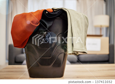 Sustainability, recycle and clothes in basket for charity, donation and giveaway in living room. Sustainable fashion, reusable and container with clothing for cleaning wardrobe, declutter and reuse 137411032