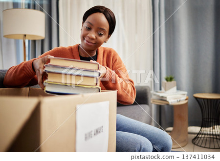 Donation box, charity and woman smile with books for nonprofit and cardboard container at home. Education textbook, donating and house with giveaway and spring cleaning for poverty with packing Donation box, charity and woman smile with books for nonprofit and cardboard container at home. Education textbook, donating and house with giveaway and spring cleaning for poverty with packing 137411034