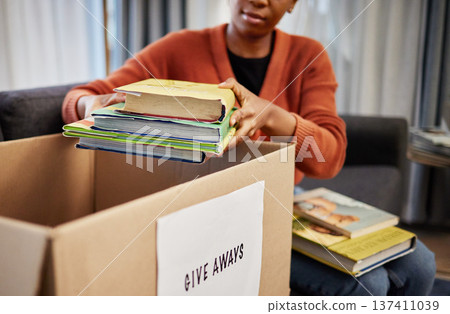Donation box, charity and woman with books for nonprofit and cardboard container at home. Education textbook, donating and house with giveaway and spring cleaning for community support with packing 137411039