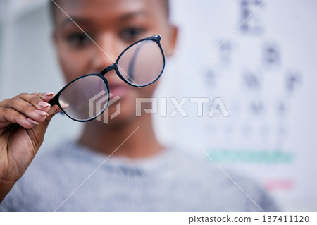 Optometry, eyesight and black woman with glasses for vision, eye care and optical health in clinic. Healthcare, optometrist and person with prescription lens, frames and spectacles for testing eyes Optometry, eyesight and black woman with glasses for vision, eye care and optical health in clinic. Healthcare, optometrist and person with prescription lens, frames and spectacles for testing eyes 137411120