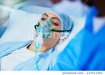 Hospital, anesthesia and woman with oxygen mask in surgery for medical service, operation and procedure. Healthcare, doctor and surgeons with gas, breathing and ventilation equipment for patient 137411463